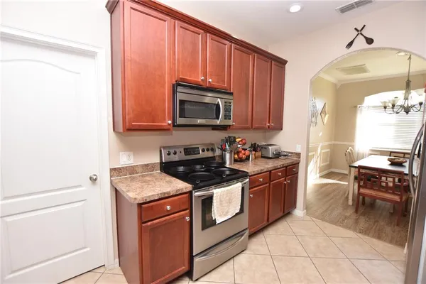 a kitchen with stainless steel appliances granite countertop a stove a sink and a microwave