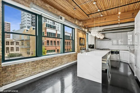 a kitchen with stainless steel appliances granite countertop a refrigerator and a stove top oven