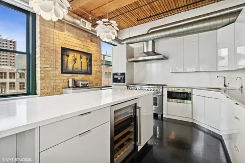 a kitchen with cabinets stainless steel appliances and wooden floor