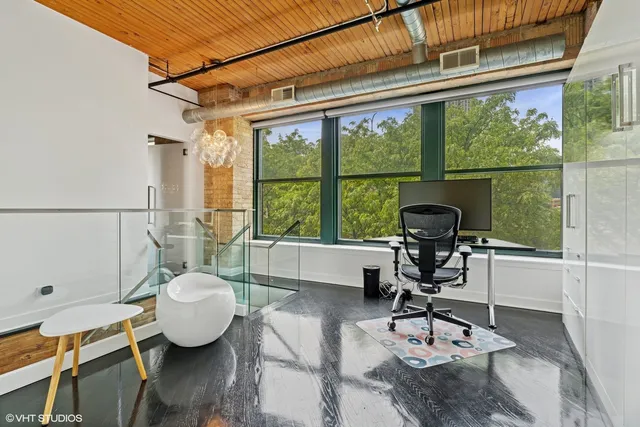 a view of a workspace with furniture and wooden floor