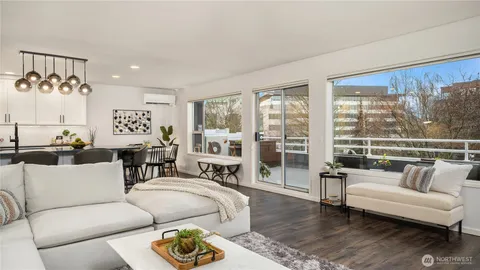 a view of a dining room with furniture a potted plant and wooden floor