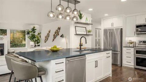 a kitchen with stainless steel appliances granite countertop a sink a stove and cabinets