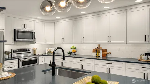 a kitchen with white cabinets white appliances and sink