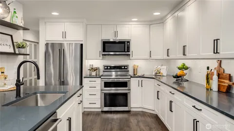 a kitchen with stainless steel appliances granite countertop sink stove top oven and microwave