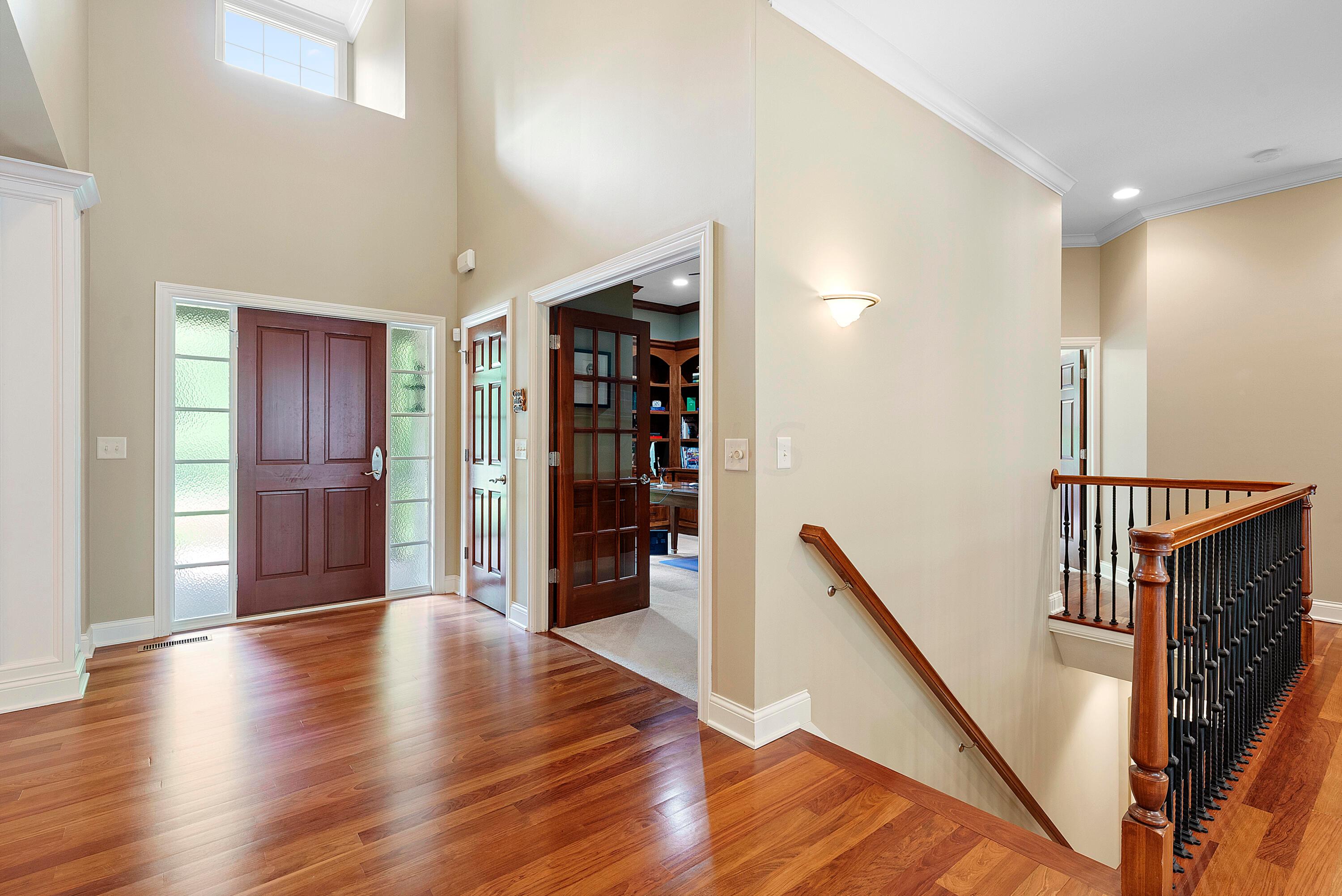 5761 Hughes Road Galena, OH 43021 - Photo 10 of 43 Welcoming entry with 14’ ceiling & Brazilian cherry flooring, insulated entry door with textured glass sidelites, guest closet. Offset staircase to the Lower Level/Basement.
