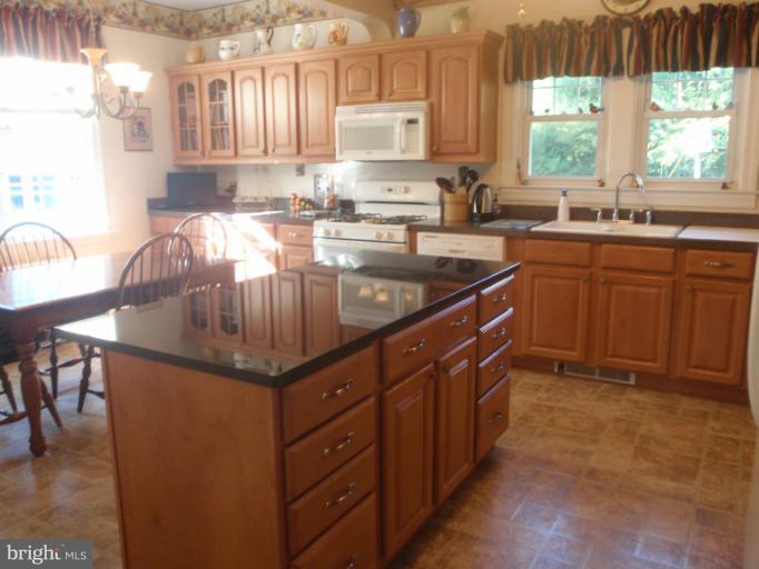 111 South Rolling Road Catonsville, MD 21228 - Photo 15 of 25 a kitchen with kitchen island granite countertop a sink window and cabinets
