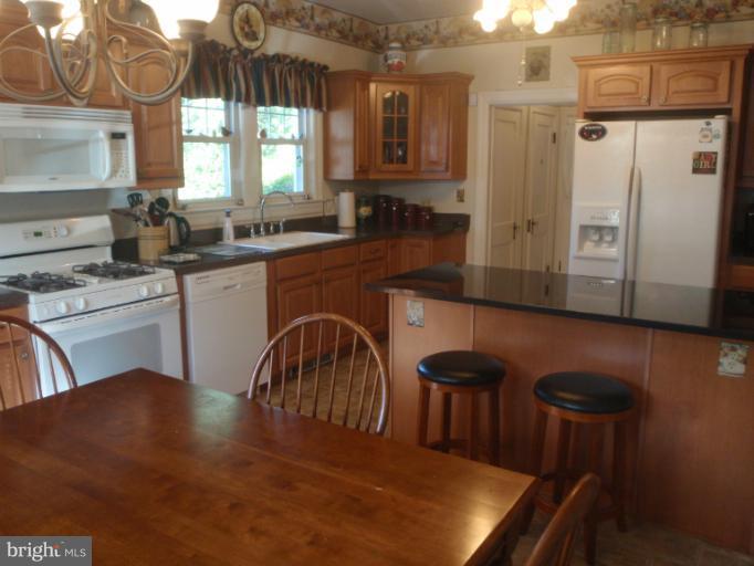111 South Rolling Road Catonsville, MD 21228 - Photo 5 of 25 a kitchen with stainless steel appliances granite countertop a stove a sink a dining table and chairs