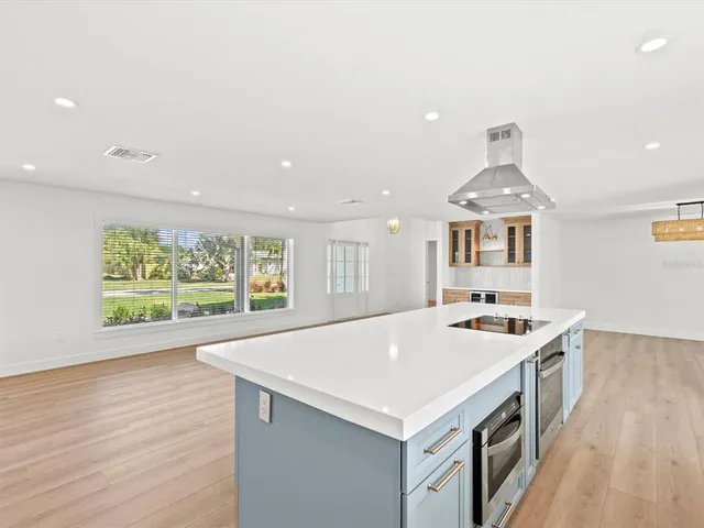 a view of kitchen with wooden floor and electronic appliances