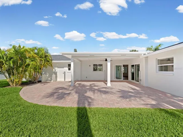 an aerial view of houses with an outdoor space and seating