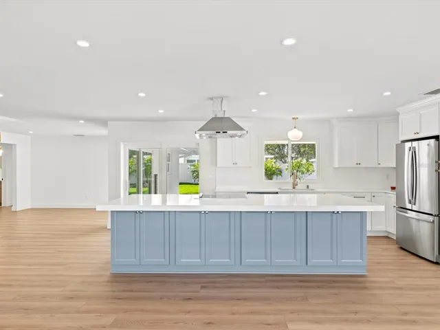 a kitchen with kitchen island a sink appliances and cabinets