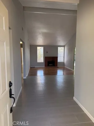 a view of an empty room with wooden floor and a fire place