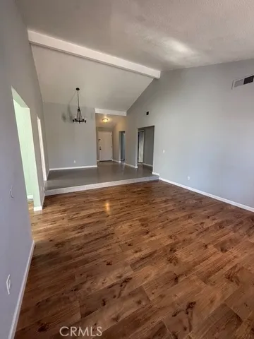 a view of empty room with wooden floor and window
