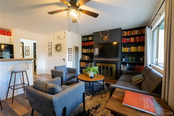 a living room with fireplace furniture and a book shelf