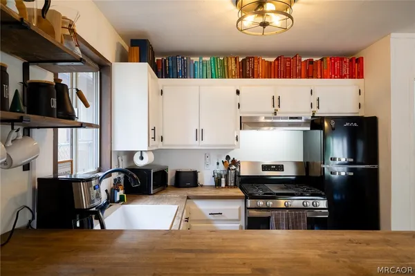 a kitchen with stainless steel appliances granite countertop a stove a sink and a refrigerator