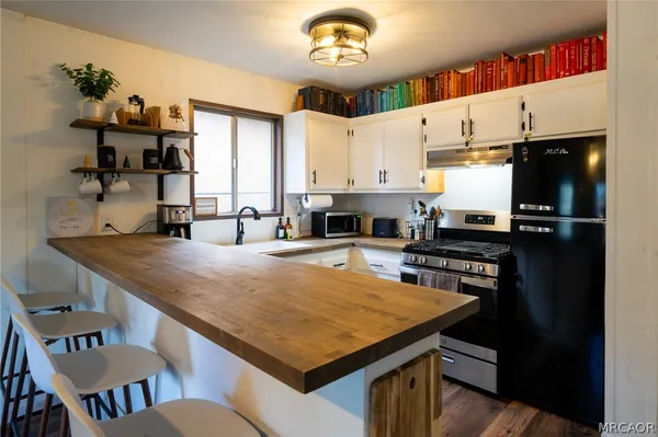 a kitchen with a stove a sink dishwasher and a refrigerator
