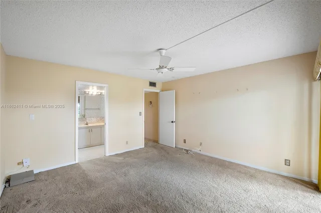 an empty room with a ceiling fan and closet area