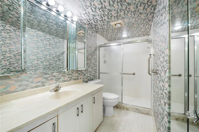 a bathroom with a double vanity sink toilet and shower