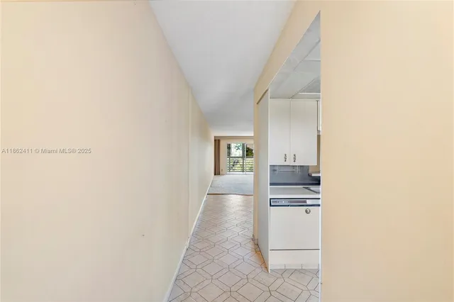 a view of a hallway to kitchen and an entryway