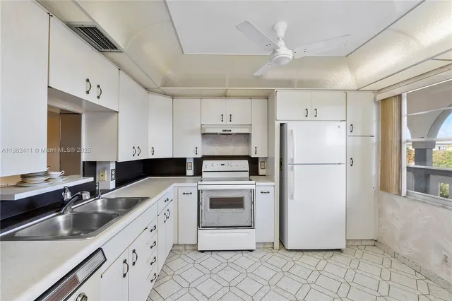 a kitchen with a white cabinets and white stainless steel appliances