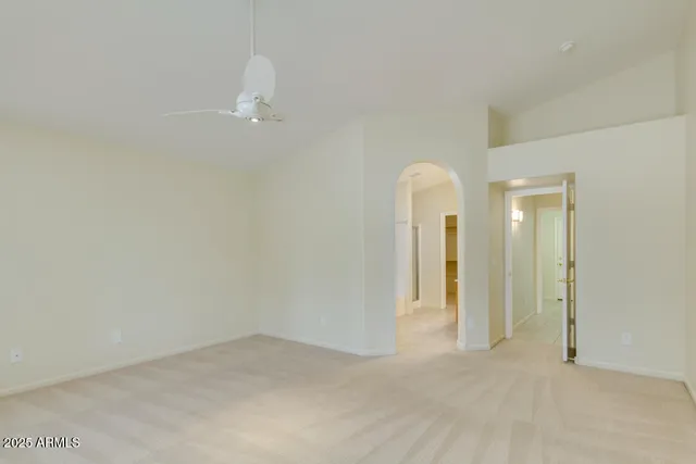 an empty room with closet and a chandelier fan