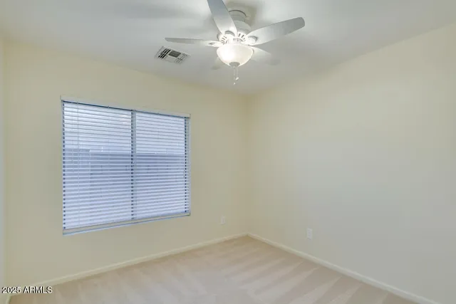 an empty room with windows and fan