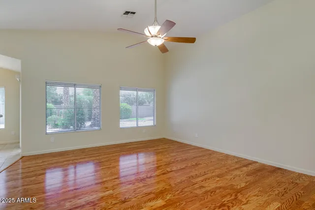 a view of a room with wooden floor and a chandelier fan