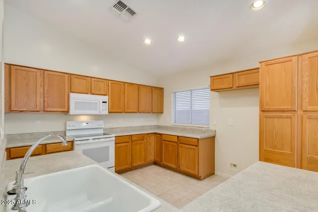 a kitchen with stainless steel appliances granite countertop a sink refrigerator and cabinets