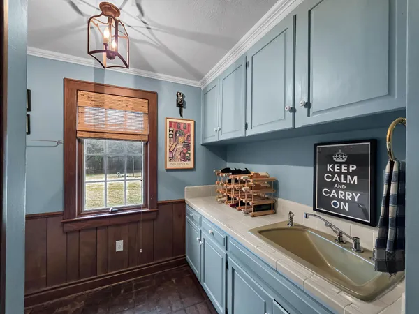 a kitchen with granite countertop a sink window and cabinets