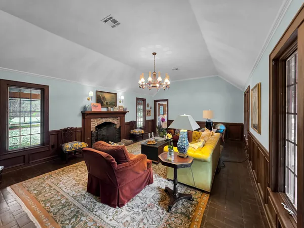 a living room with furniture a fireplace and a chandelier