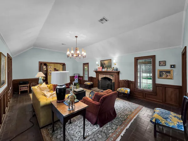 a living room with furniture a dining table and a fireplace