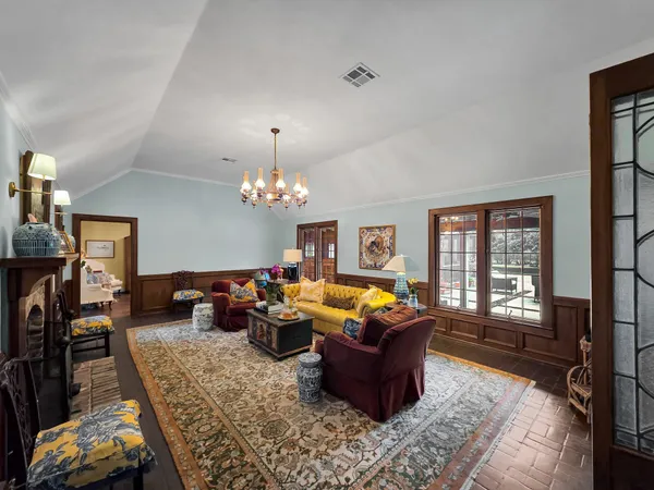 a living room with furniture a fireplace and a chandelier