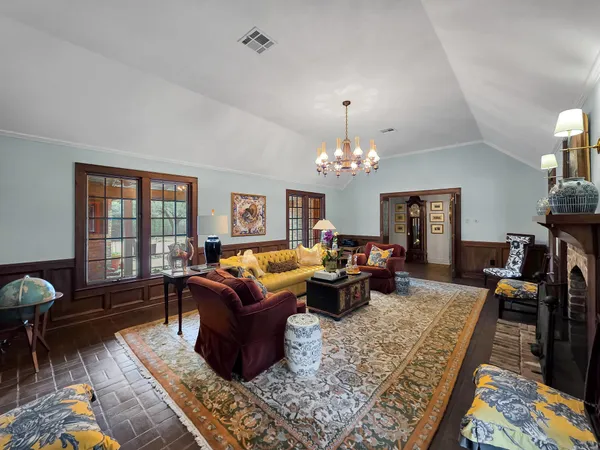 a living room with furniture a chandelier and a rug