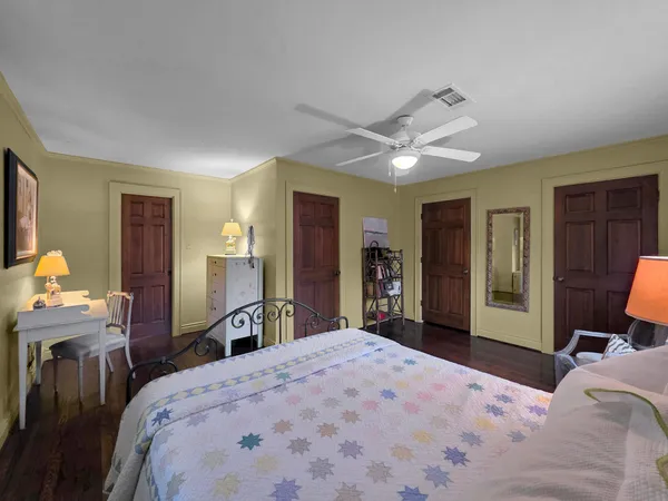 a bedroom with a bed and a large mirror on dresser