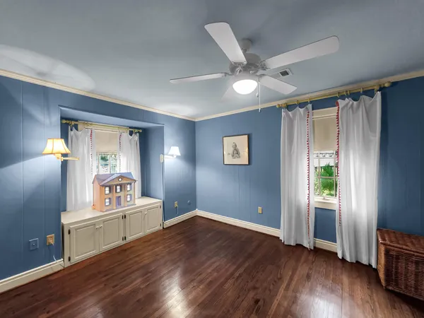 a living room with hardwood flooring and ceiling fan