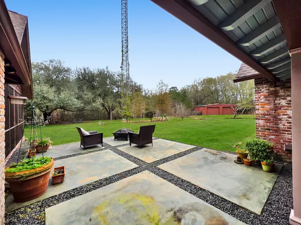 a view of a patio with couches chairs and a big yard