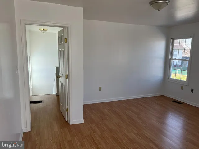 an empty room with wooden floor and a window