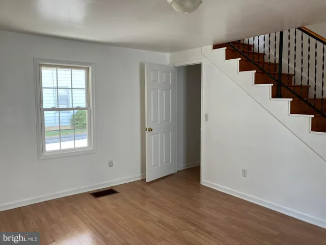 an entryway of a house with wooden floor and windows