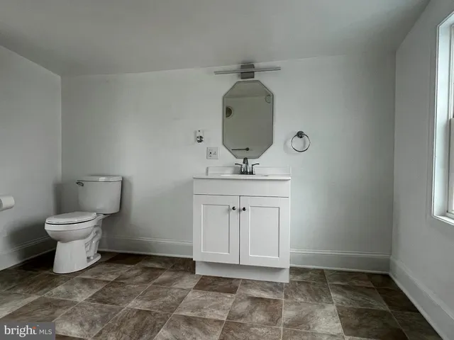 a bathroom with a toilet a sink and a mirror