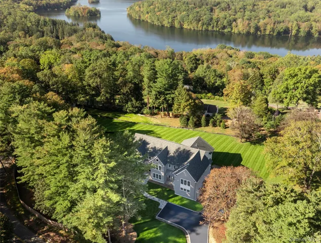 an aerial view of a house with a yard lake and outdoor seating