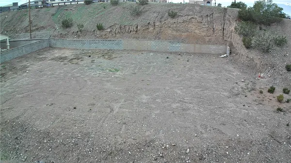 a view of a dry yard with wooden fence