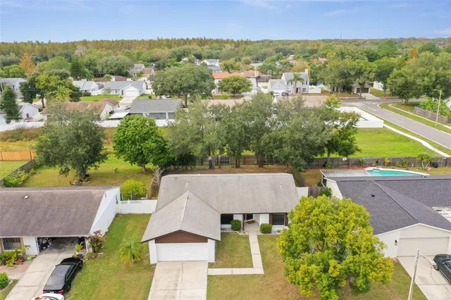 an aerial view of residential houses with outdoor space and trees