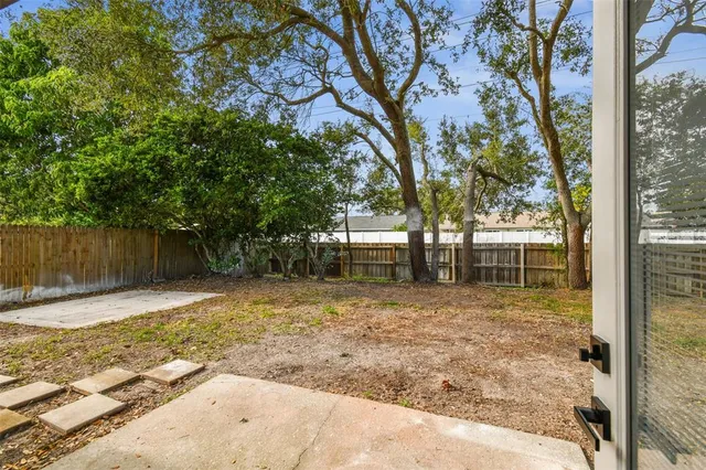 a view of a house with a backyard and a tree