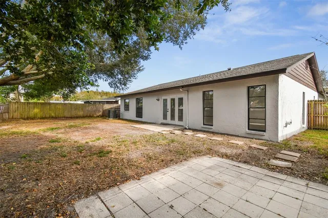 a large white kitchen with kitchen island a sink wooden floor and stainless steel appliances