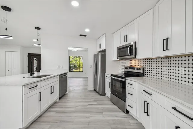 a view of large kitchen with wooden floor and windows