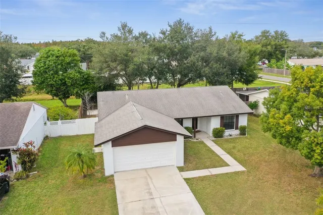 an aerial view of residential houses with outdoor space and trees