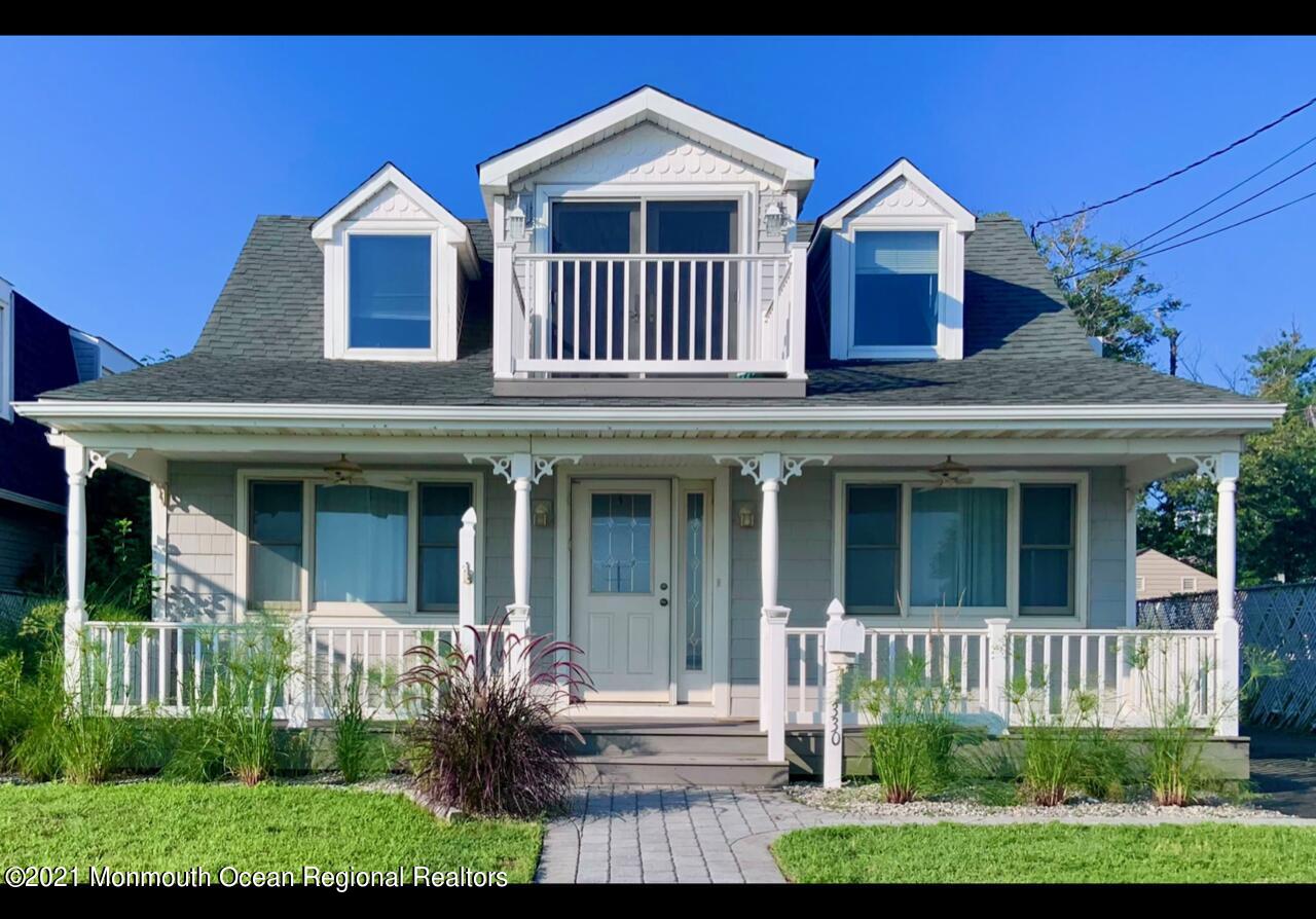 a view of a brick house with large windows and a small yard