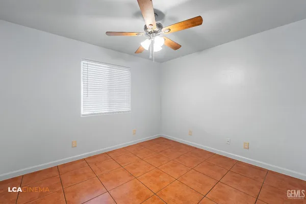 an empty room with a window and a fan