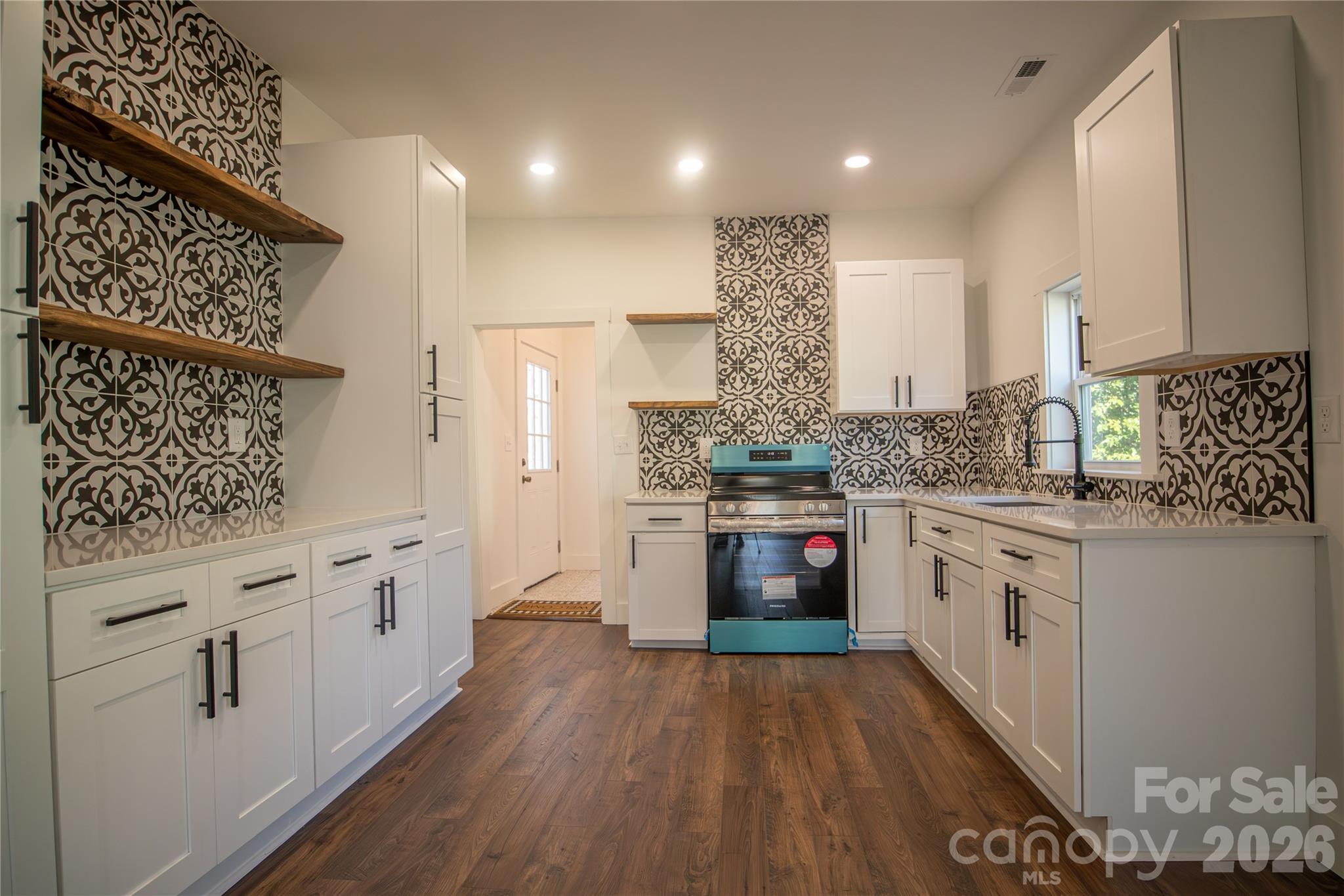 929 South Long Street Salisbury, NC 28144 - Photo 16 of 30 a kitchen with granite countertop white cabinets and white appliances