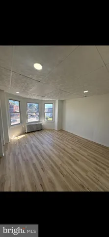 a view of empty room with kitchen