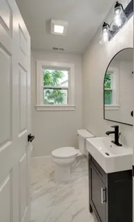 a bathroom with a sink toilet and a mirror